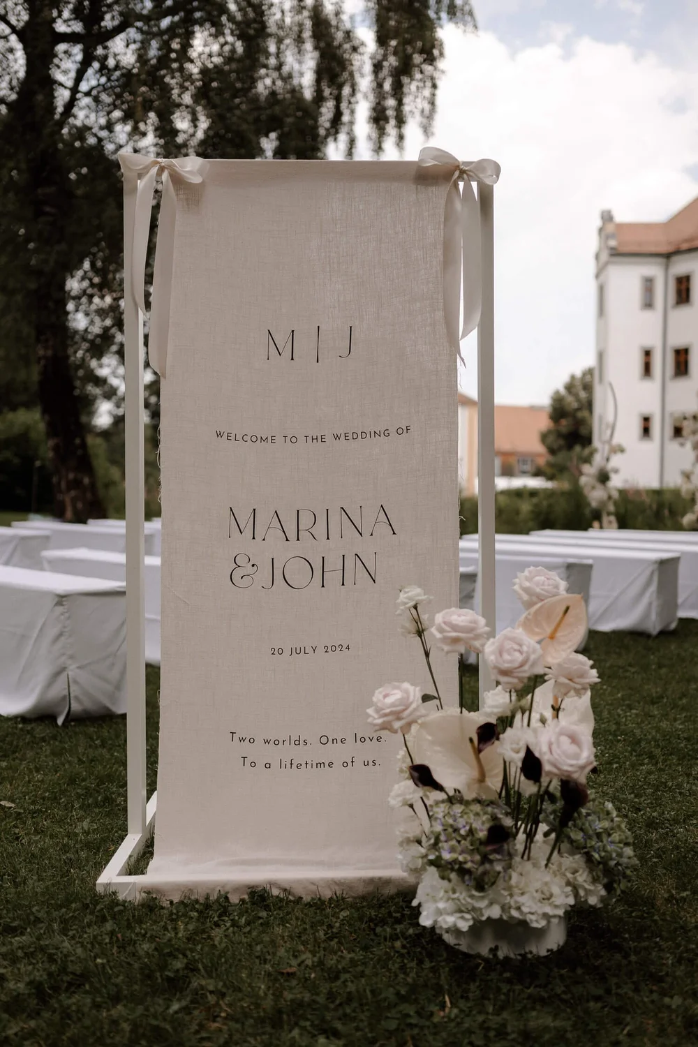 Willkommensschild mit Blumen und Schloss