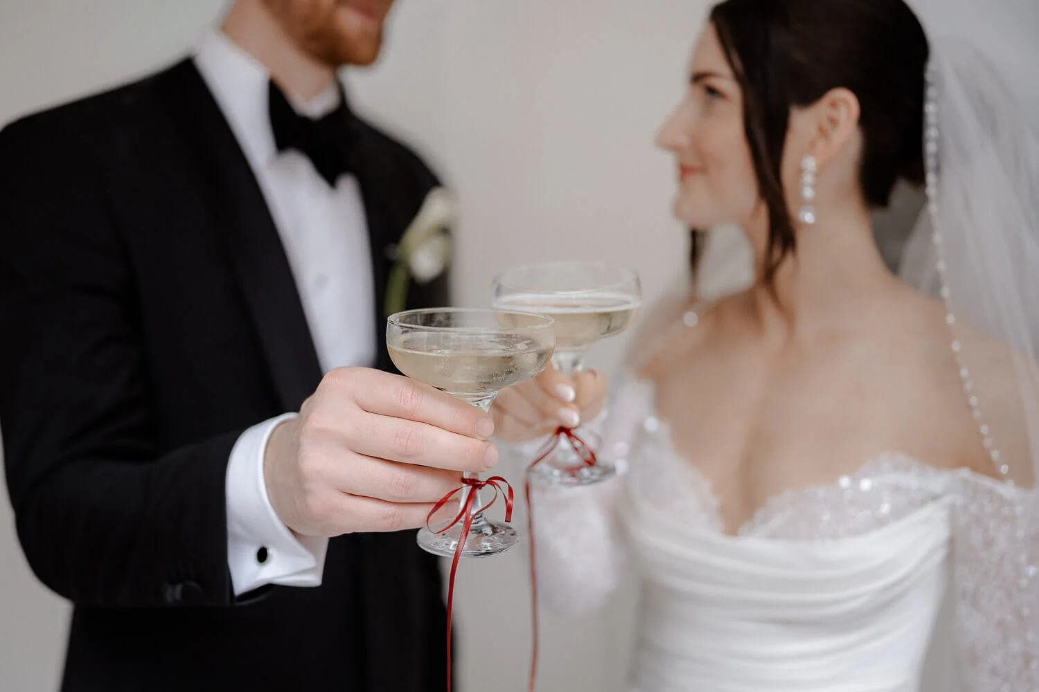 Hochzeitspaar mit Sektgläsern beim Anstoßen.