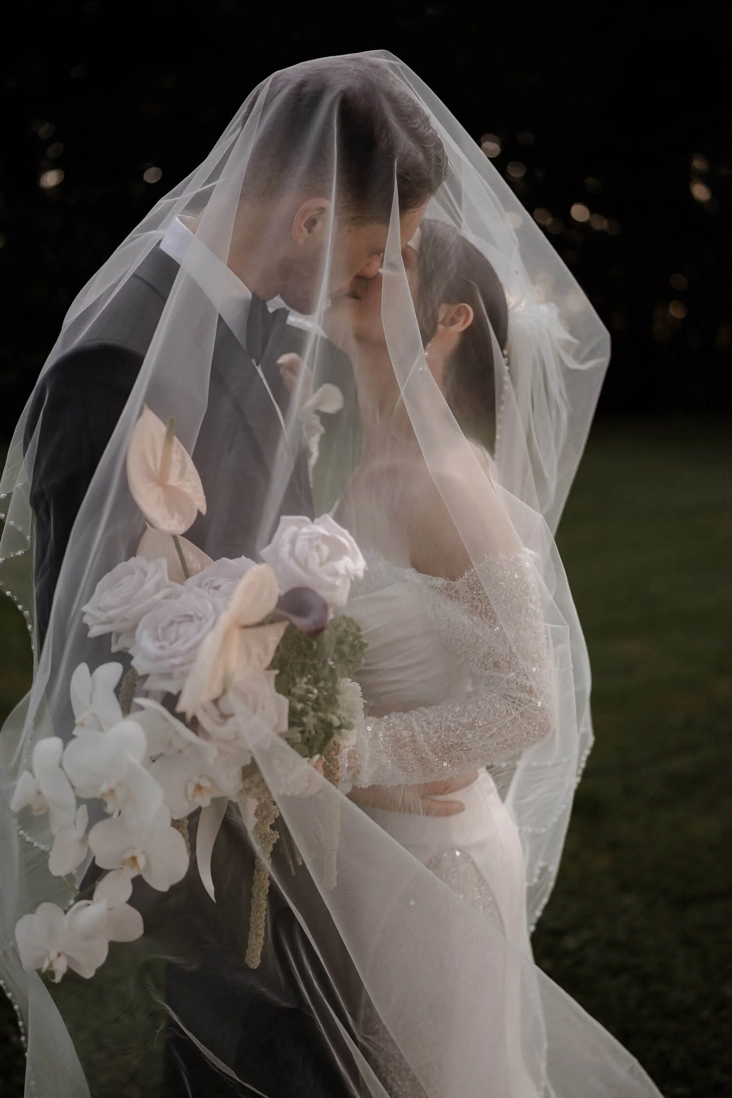 Brautpaar unter Schleier beim Kuss – Hochzeitsfotograf München