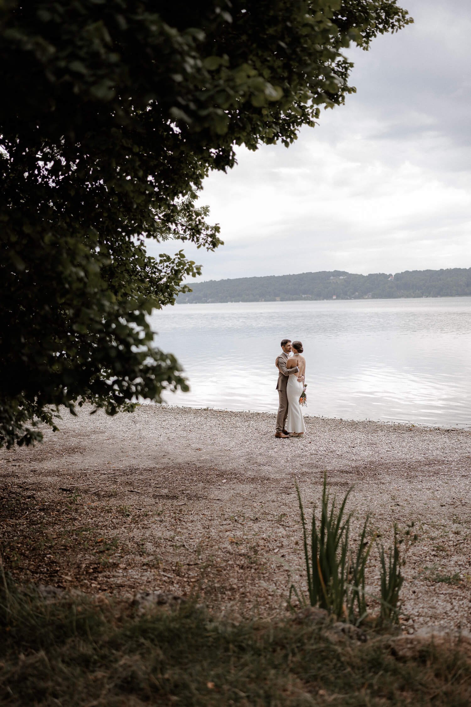 Weites Paarporträt am Seeufer – roseninsel starnberger see hochzeit