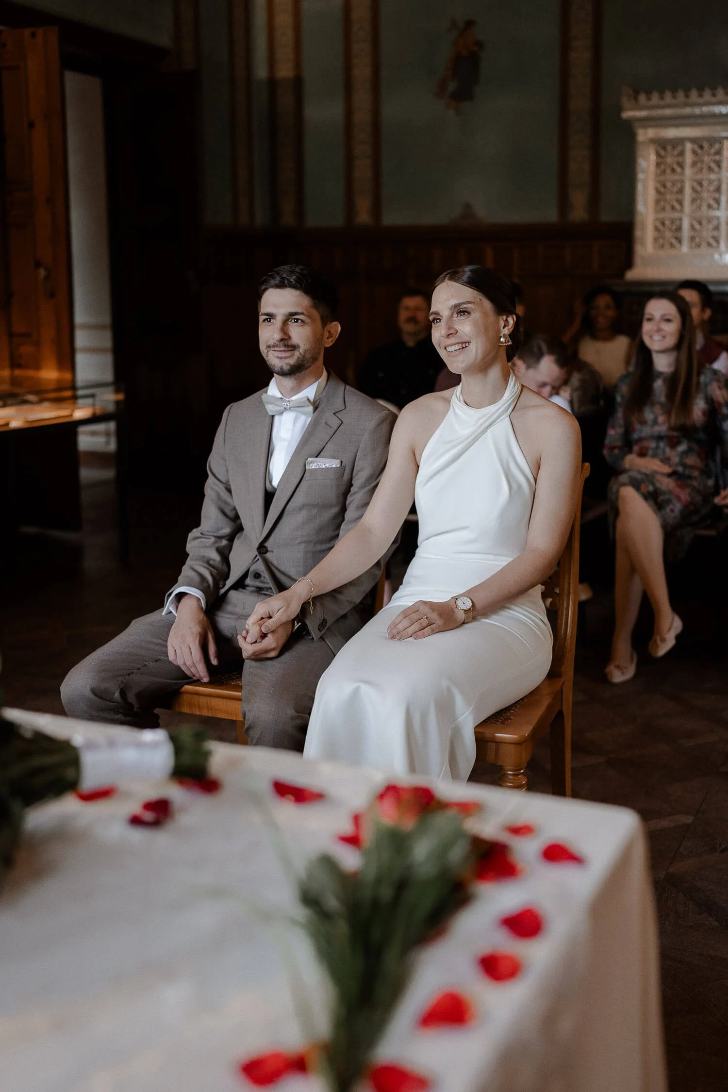 Bräutigam steckt Ring an, Gäste im Hintergrund – heiraten auf der roseninsel