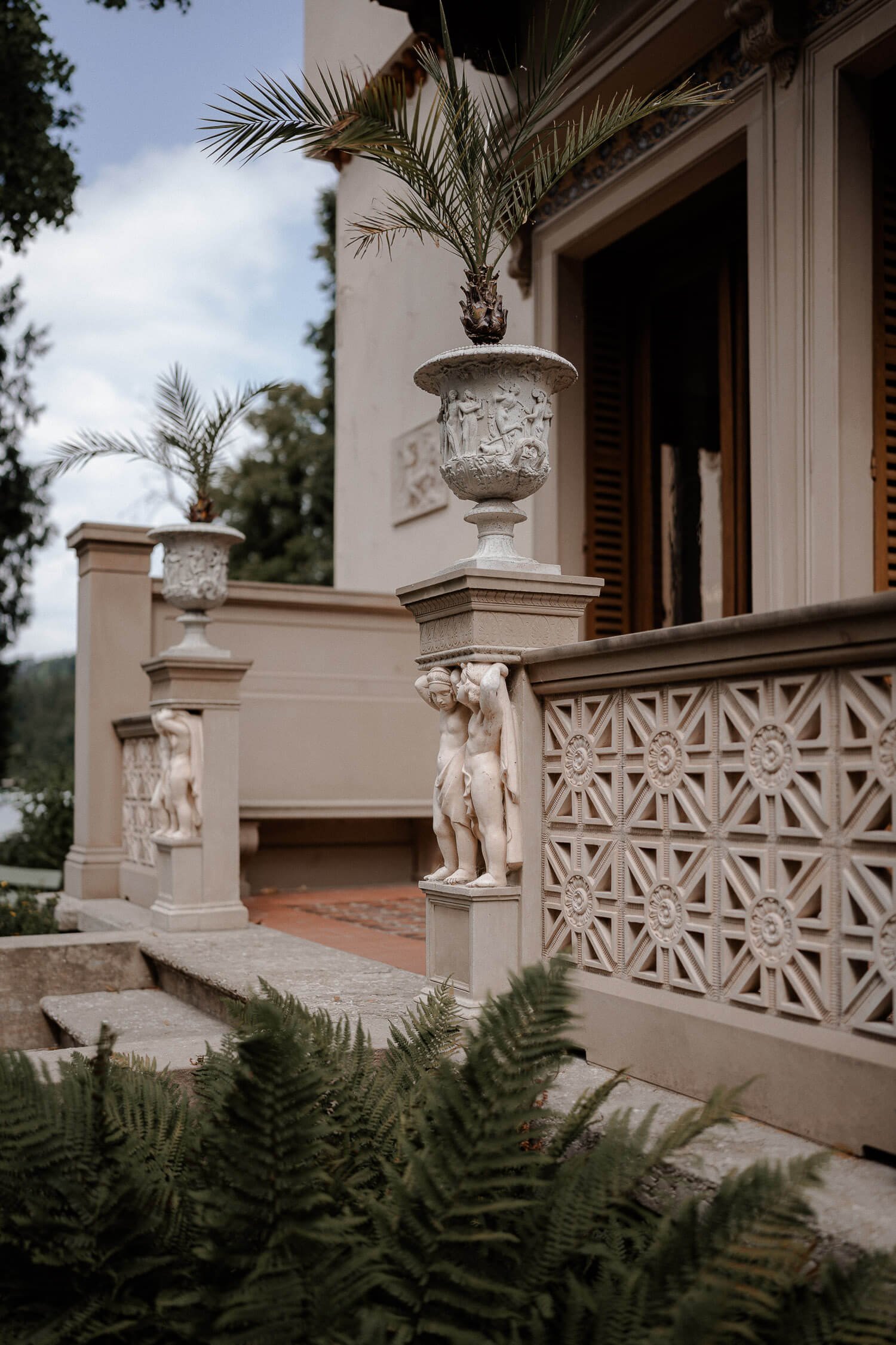 Detail Architektur: Balustrade/Urnen mit Palmen, Fassade &amp; Farn im Vordergrund – roseninsel standesamt villa details architektur