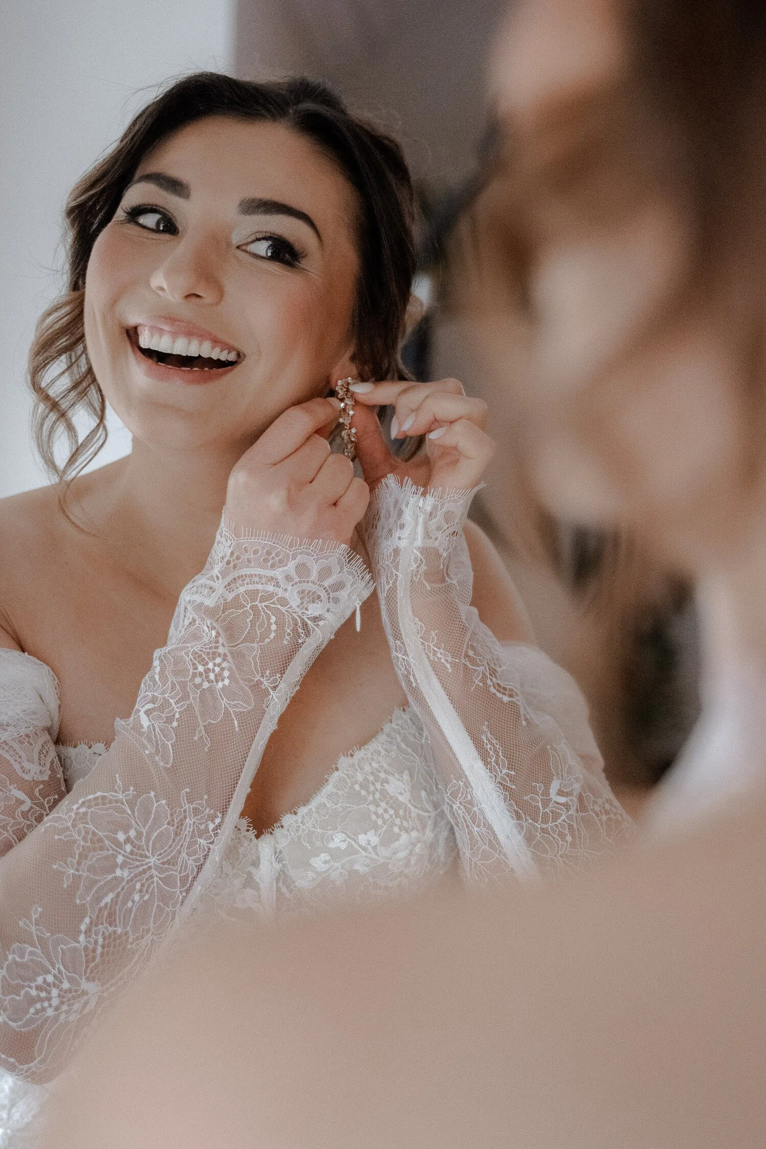 Braut steckt Ohrring an –  Getting Ready