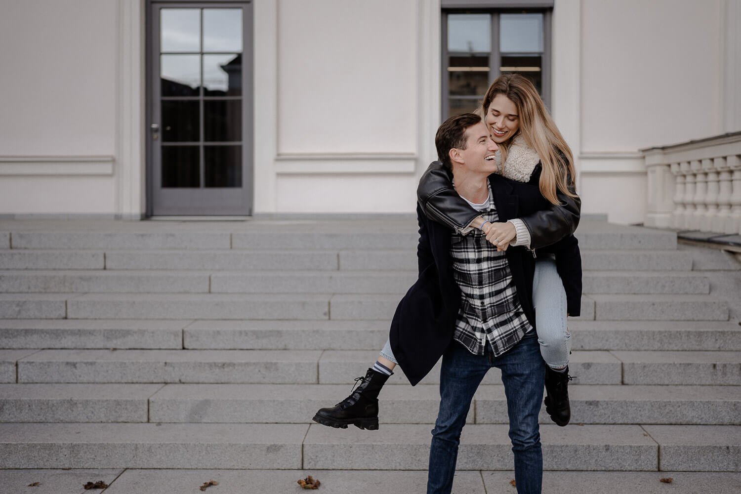 Lustiges Paarshooting München mit Huckepack auf Treppe