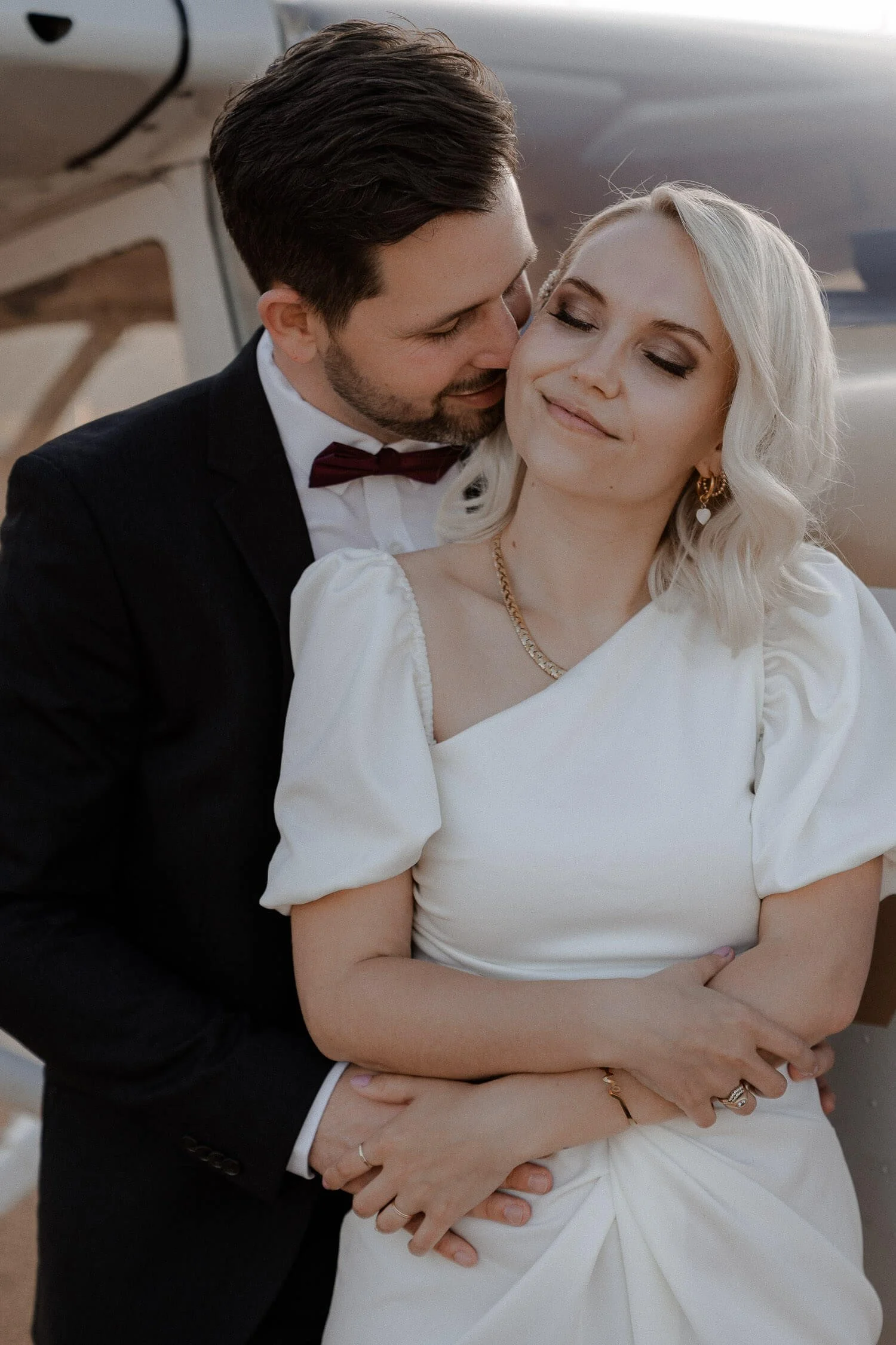 Verliebtes Brautpaar vor Flugzeug, aufgenommen von einem Wedding Photographer in Munich.