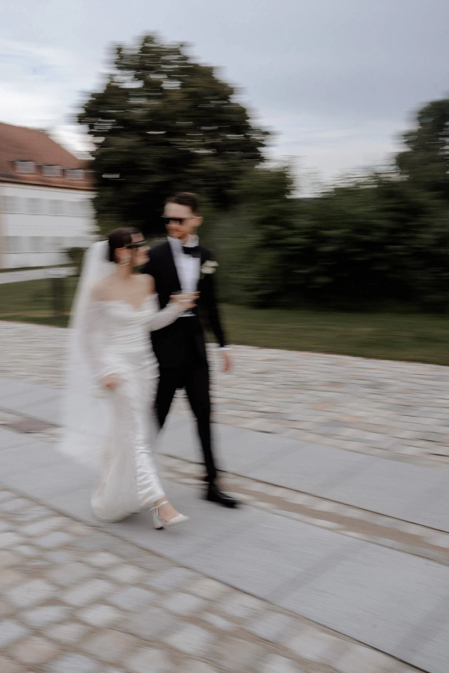 Hochzeitspaar in Bewegung vor Schloss Hohenkammer fotografiert.