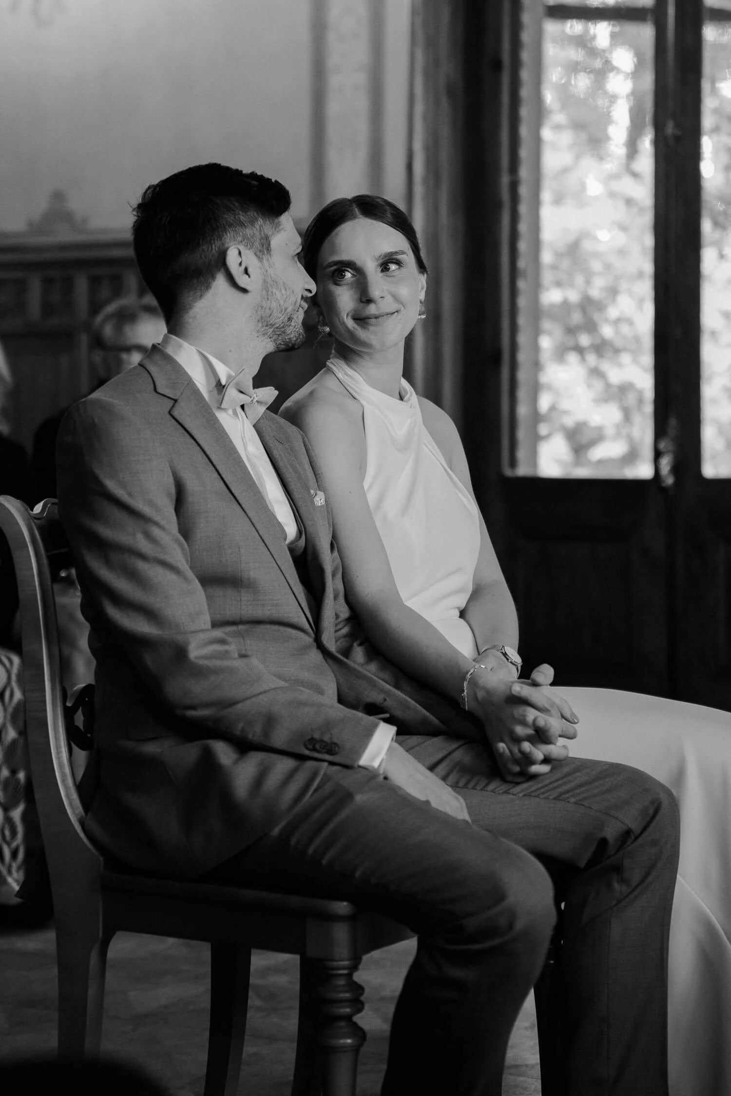 Brautpaar sitzt lächelnd im Trauzimmer – standesamt roseninsel starnberger see