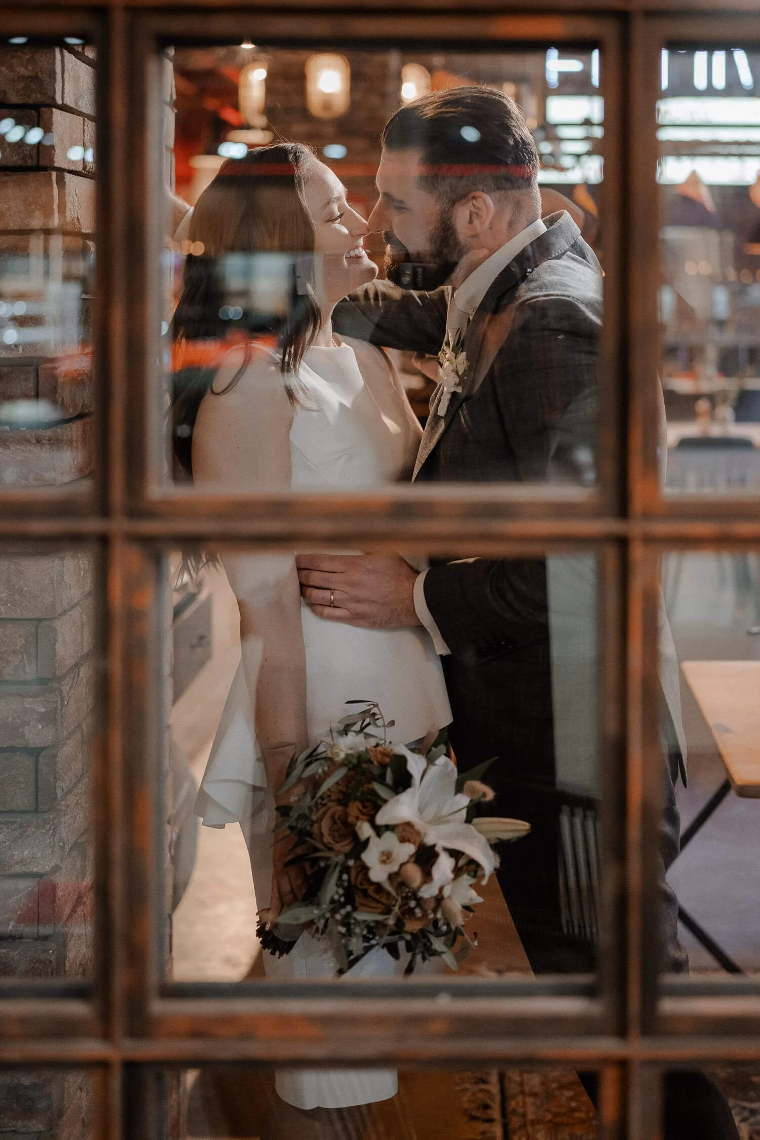 Brautpaar-hinter-Fenster-Kuss-Strauss.jpg