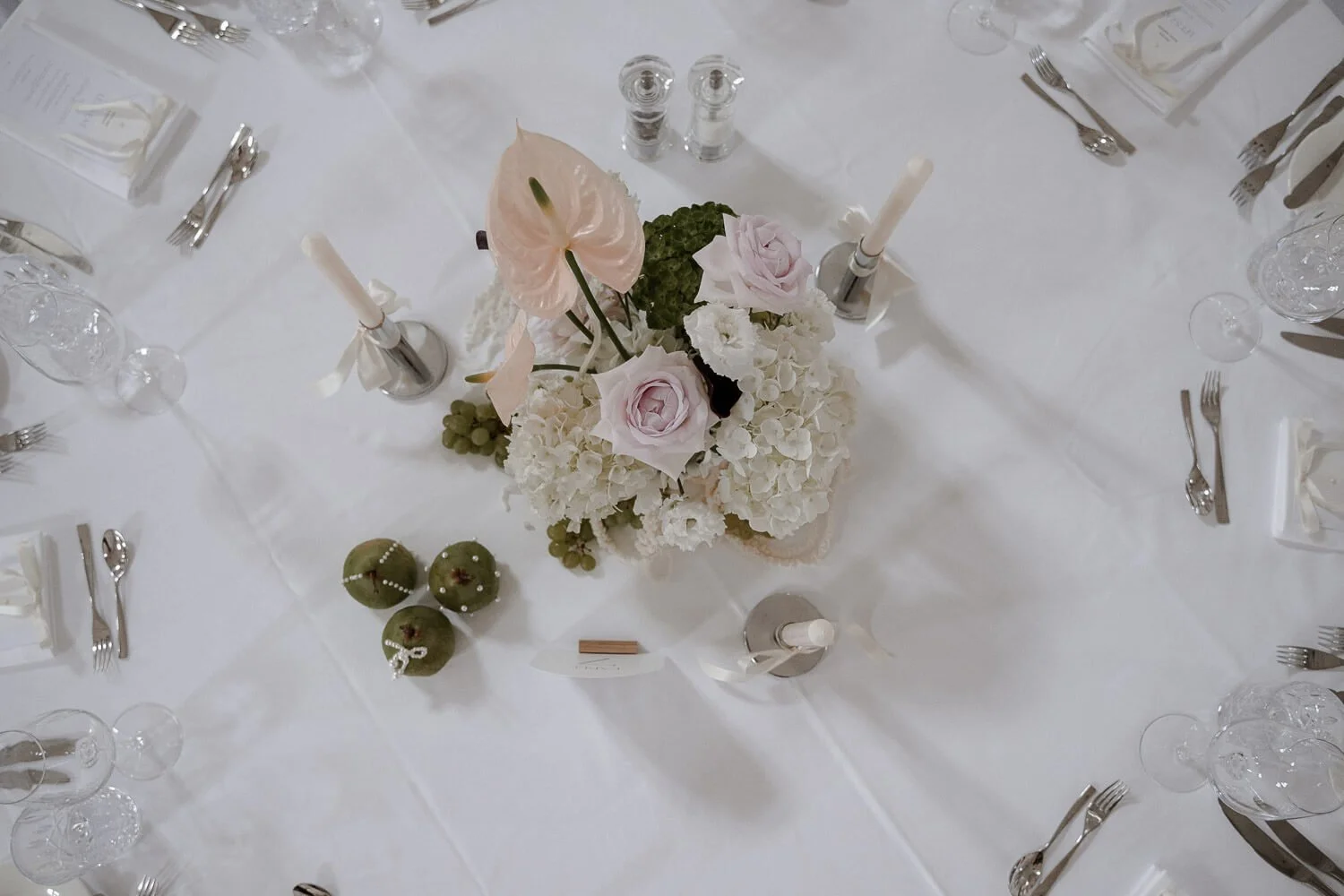 Elegante Tischdeko mit Blumen und Birnen bei Hochzeit.