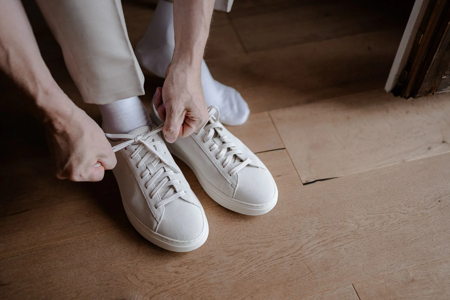 Bräutigam schnürt Sneaker vor Hochzeit