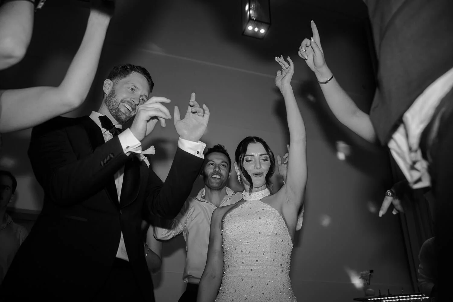 Hochzeitsparty mit tanzendem Brautpaar in München bei Nacht