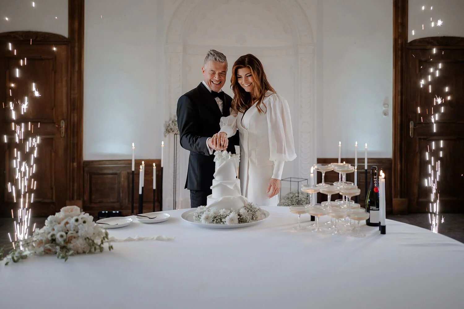 Tortenschnitt mit Wunderkerzen – professionelle Hochzeitsbilder im Saal