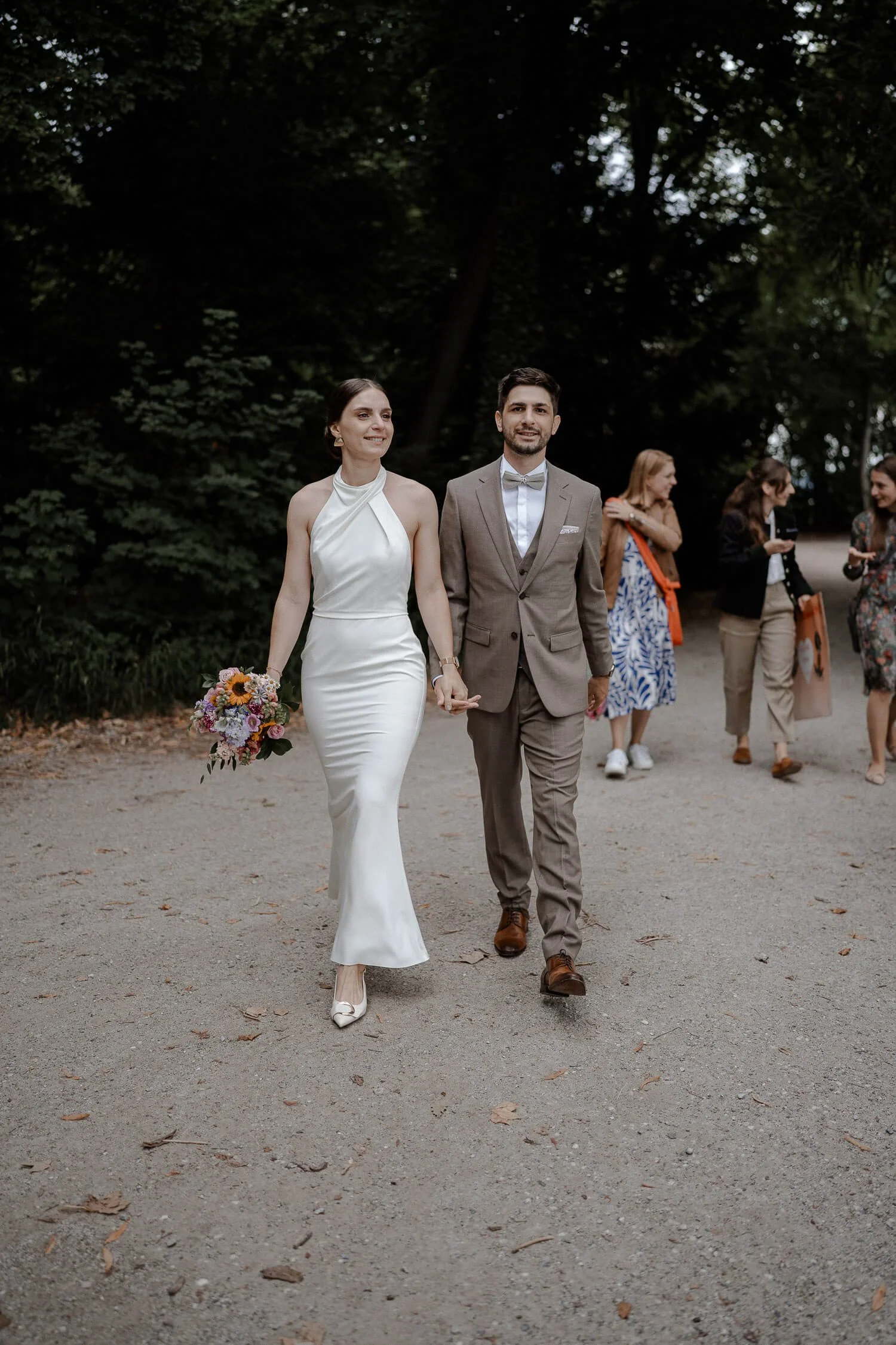 Brautpaar läuft mit Gästen durch den Park – roseninsel starnberger see hochzeit