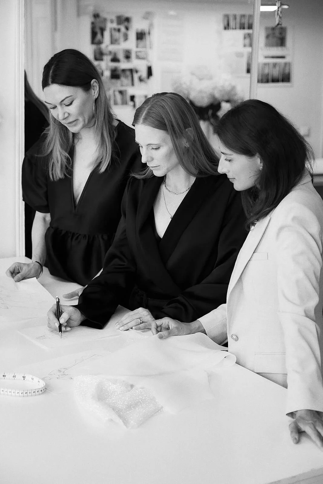 Brautkleid München: Team skizziert Entwurf am Tisch im Bridal-Atelier