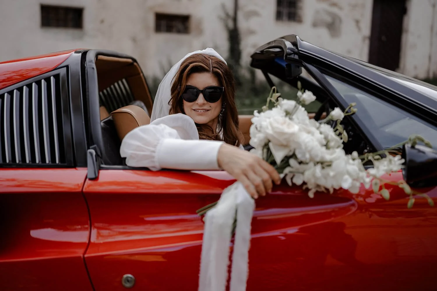 Braut im roten Cabrio mit Brautstrauß – Profi Hochzeitsfotograf Moment