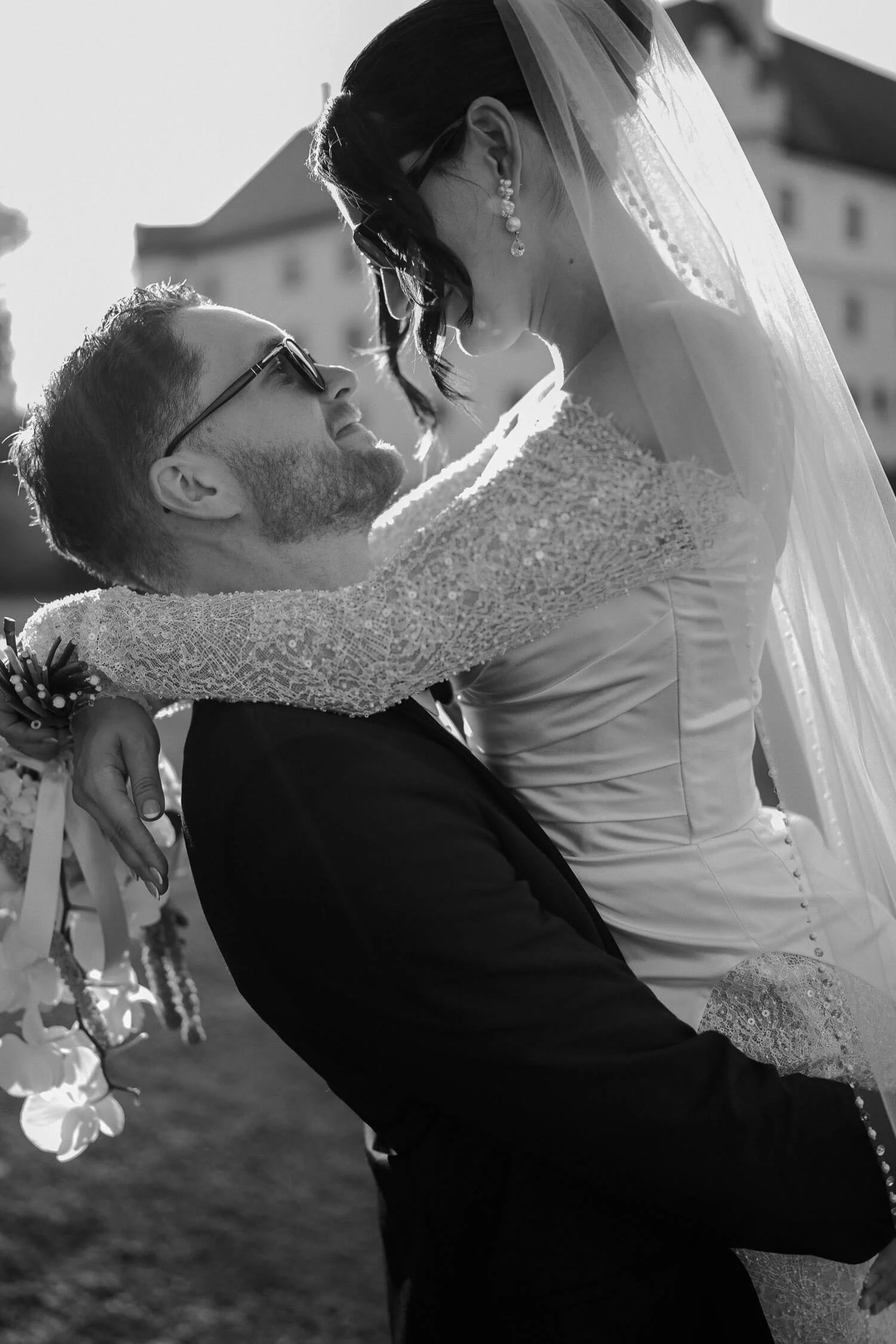 Bräutigam hebt lachende Braut vor Schloss Hohenkammer in die Luft.