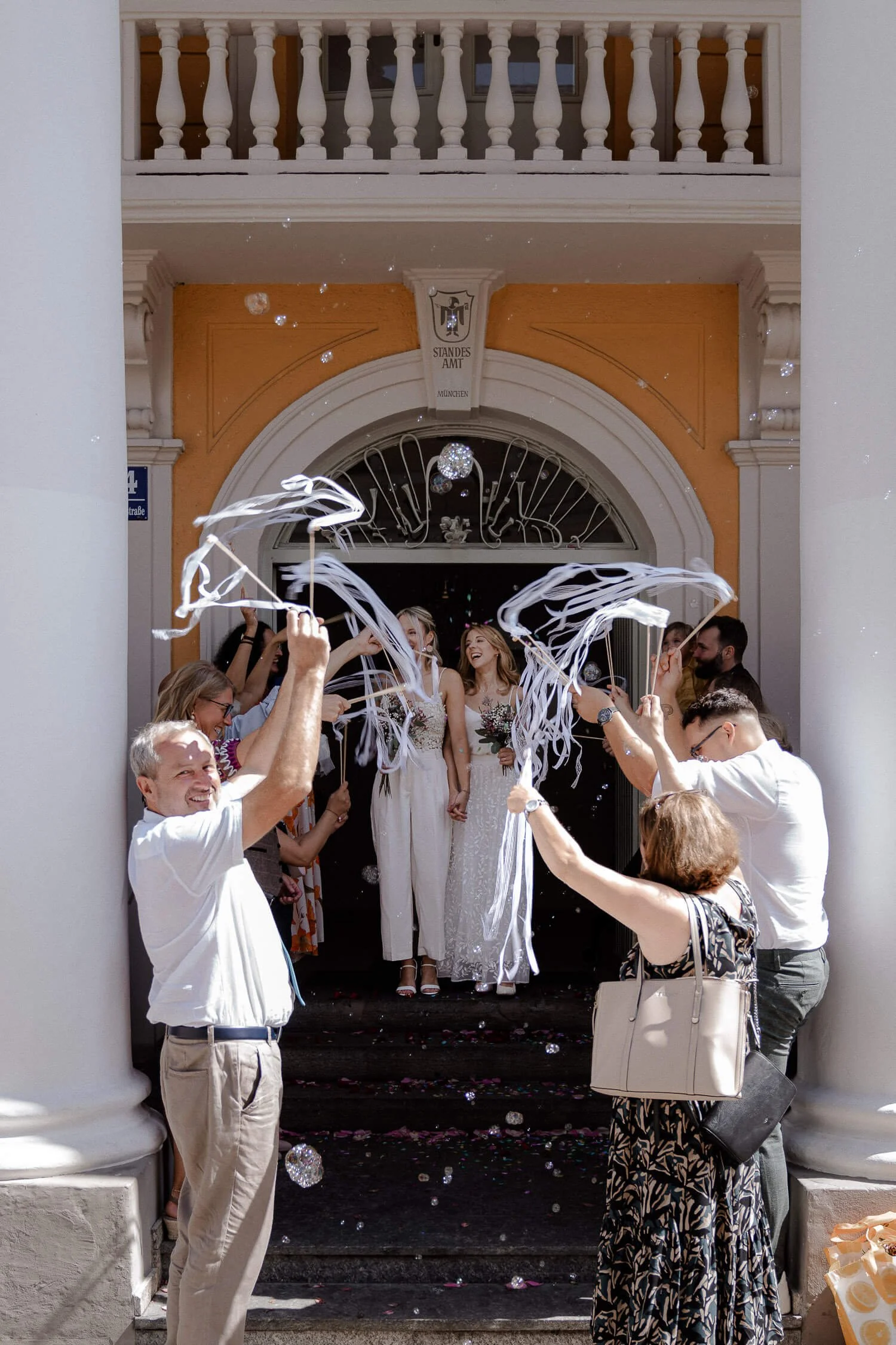 Hochzeitspaar verlässt das Standesamt Mandlstraße in München mit Gästen