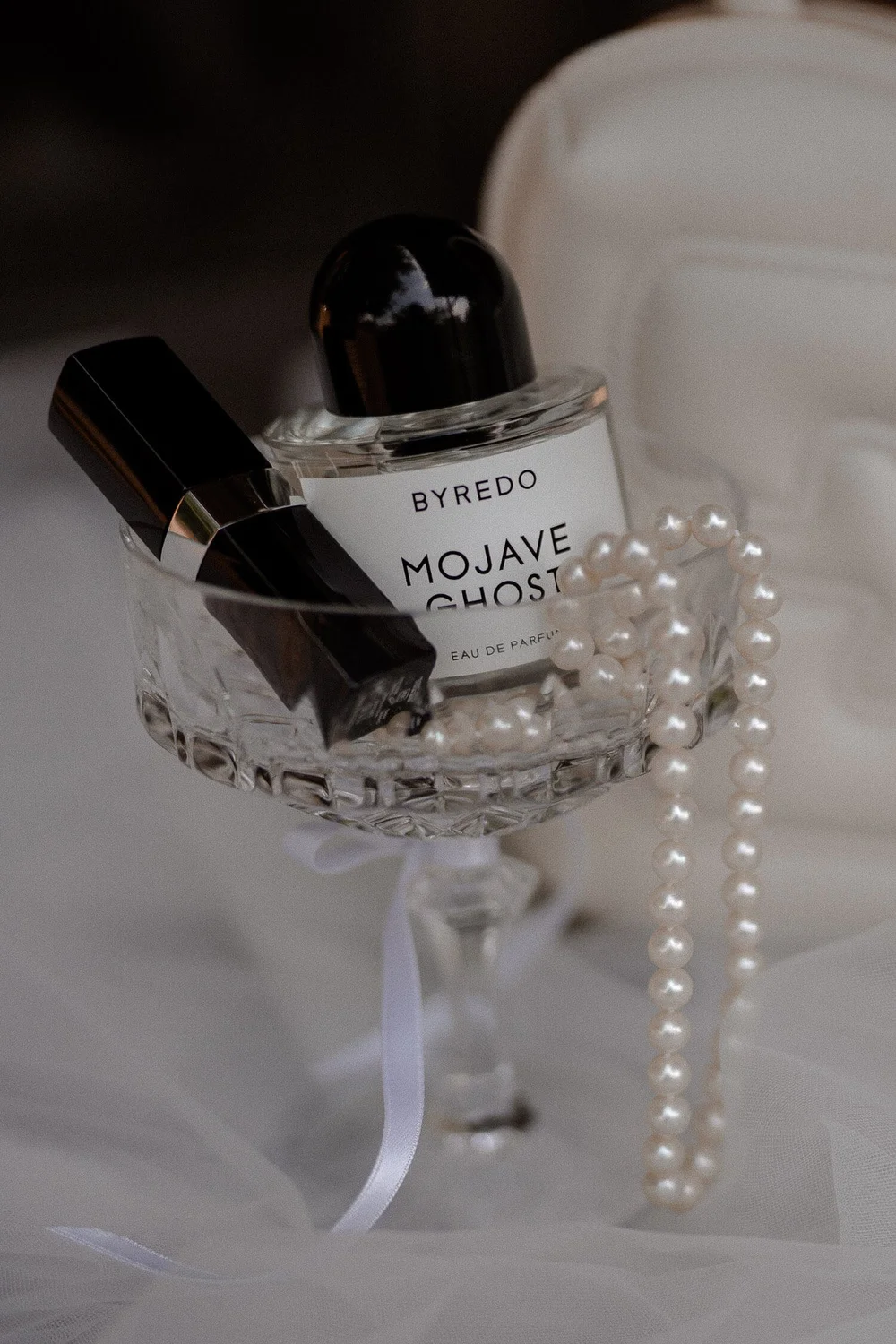 Detailaufnahme Parfum, Lippenstift, Perlen