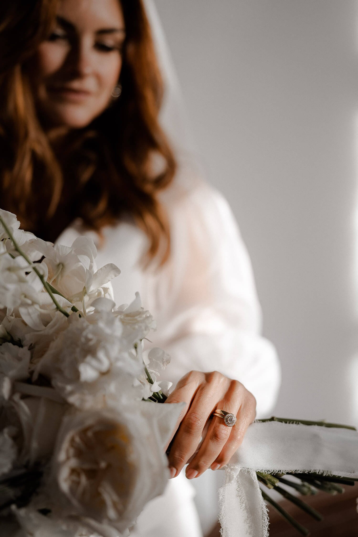Detailaufnahme der Brauthand mit Ehering und Blumenstrauß – stilvolle Hochzeitsfotografie.