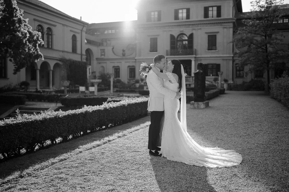 Bride and groom embracing in villa garden at sunset