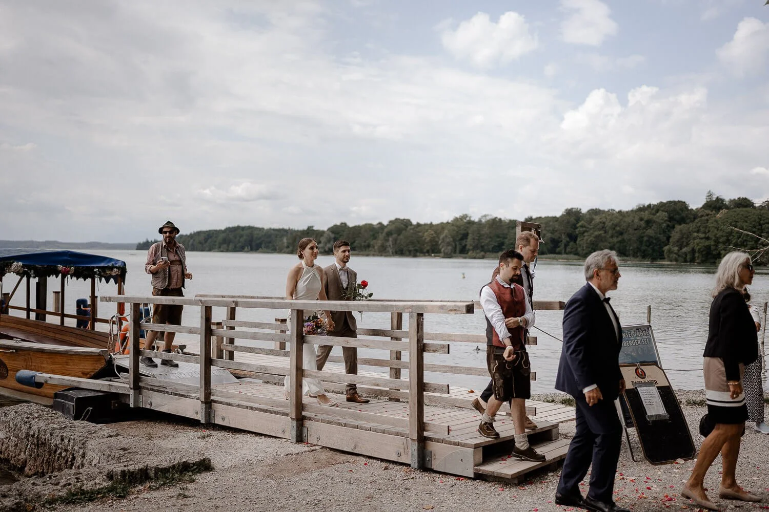 Ankunft am Steg/Bootsanleger am See, Gäste &amp; Brautpaar im Bild, dokumentarisch – roseninsel starnberger see anleger boot hochzeit ankunft reportage