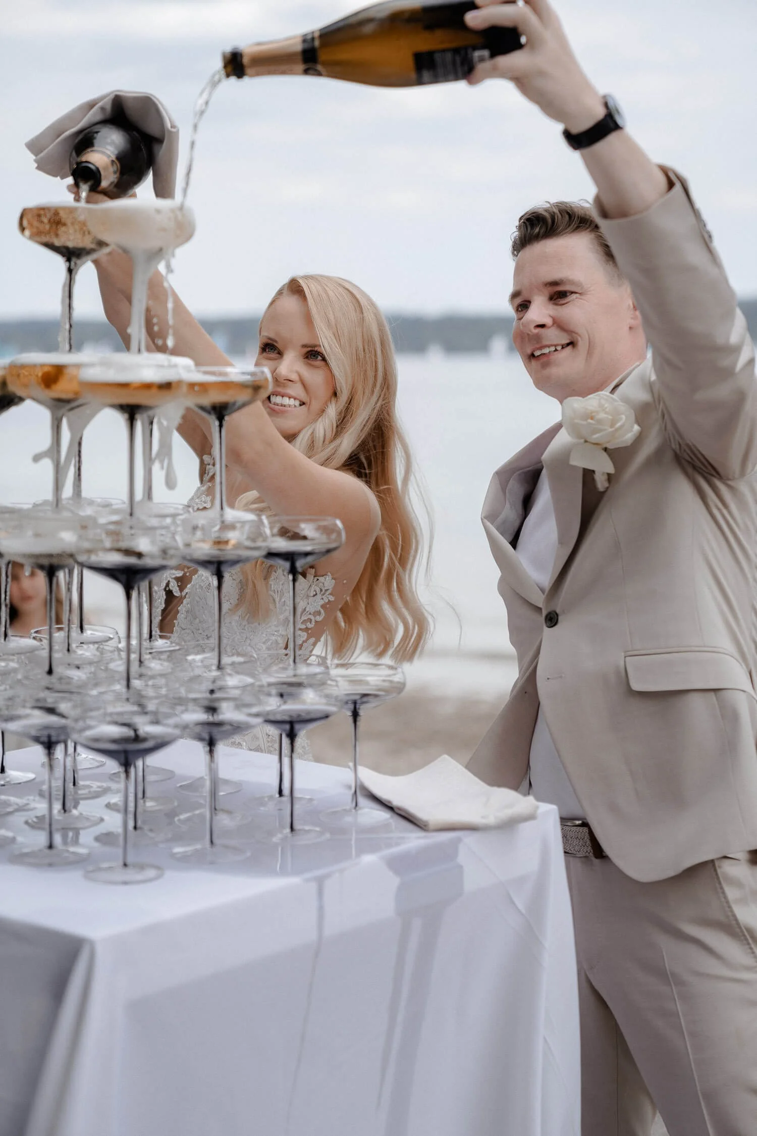 Brautpaar gießt Champagner in Glaspyramide bei Hochzeit