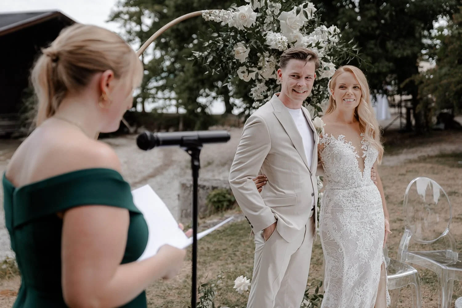 Lächelndes Brautpaar bei Rede der Trauzeugin
