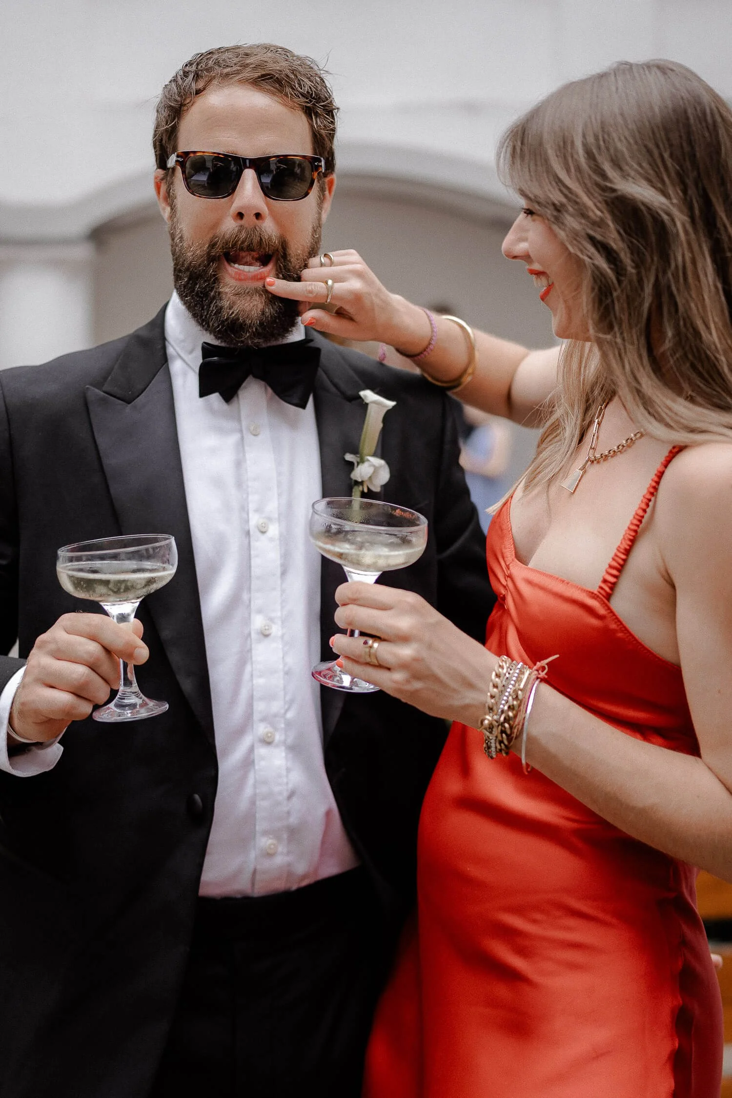 Wedding photographer Munich – stilvoller Hochzeitsgast mit Drink sorgt für lockere Stimmung