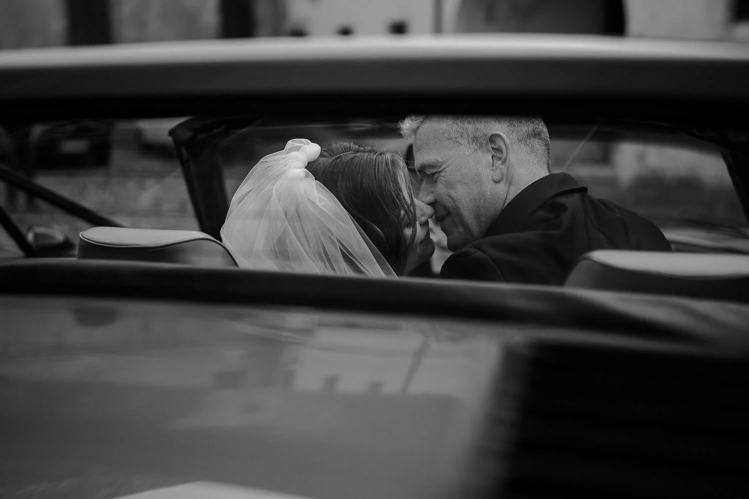 Brautpaar Kuss im Cabrio, schwarzweiß – hochzeitsfotos professionell