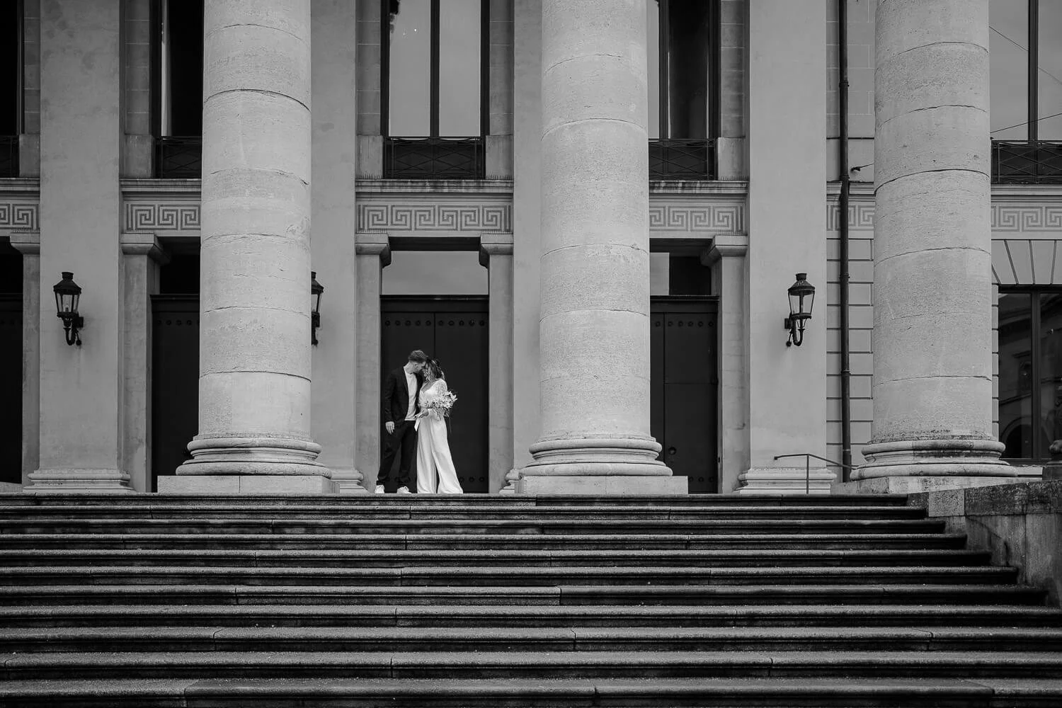 Brautpaar küsst sich vor klassischer Architektur in München