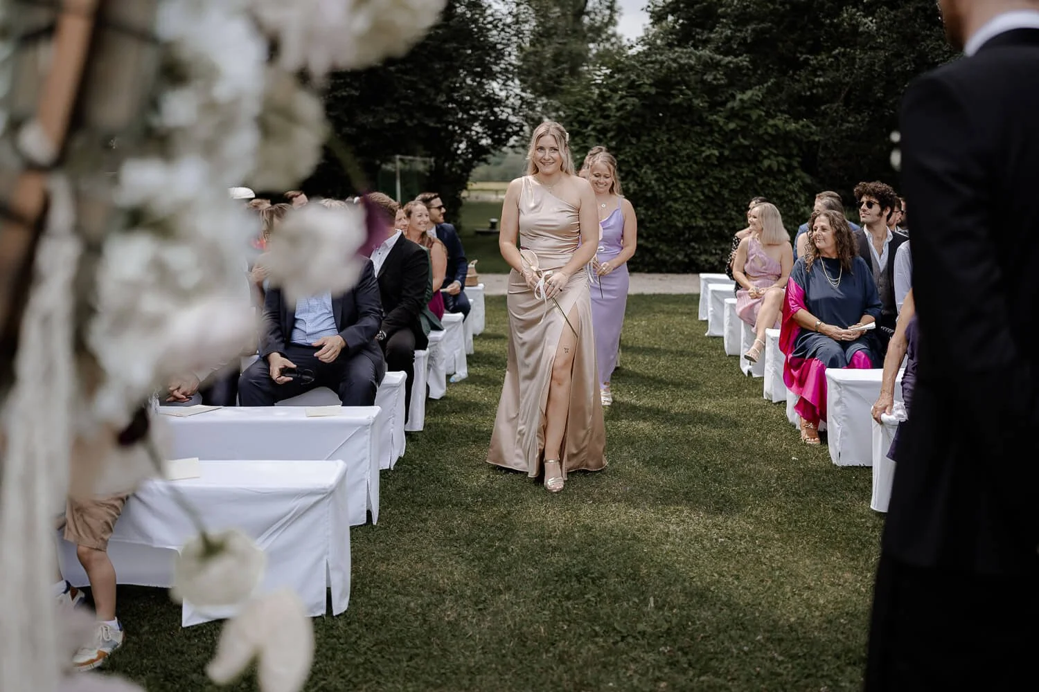 Brautjungfern laufen zur Trauung im Außenbereich von Schloss Hohenkammer.