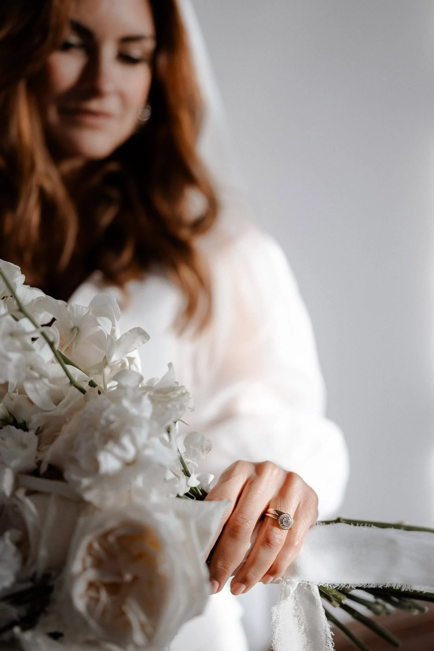 Braut mit Blumenstrauß und Verlobungsring, aufgenommen von einem Hochzeitsfotografen in München.