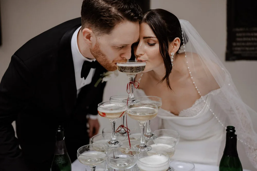 Beide trinken aus Champagnerpyramide