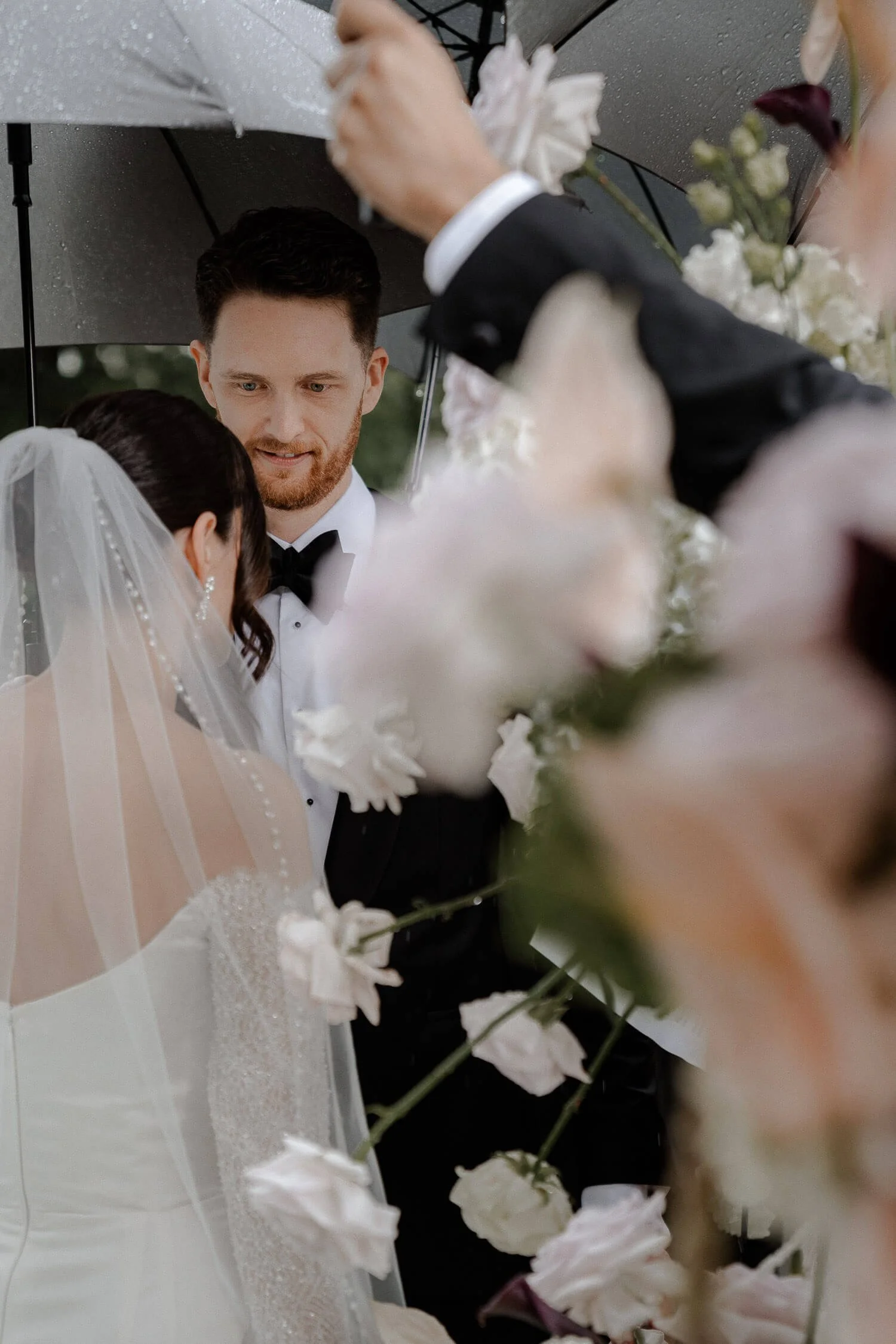 Hochzeitspaar unter Regenschirm bei Trauung.