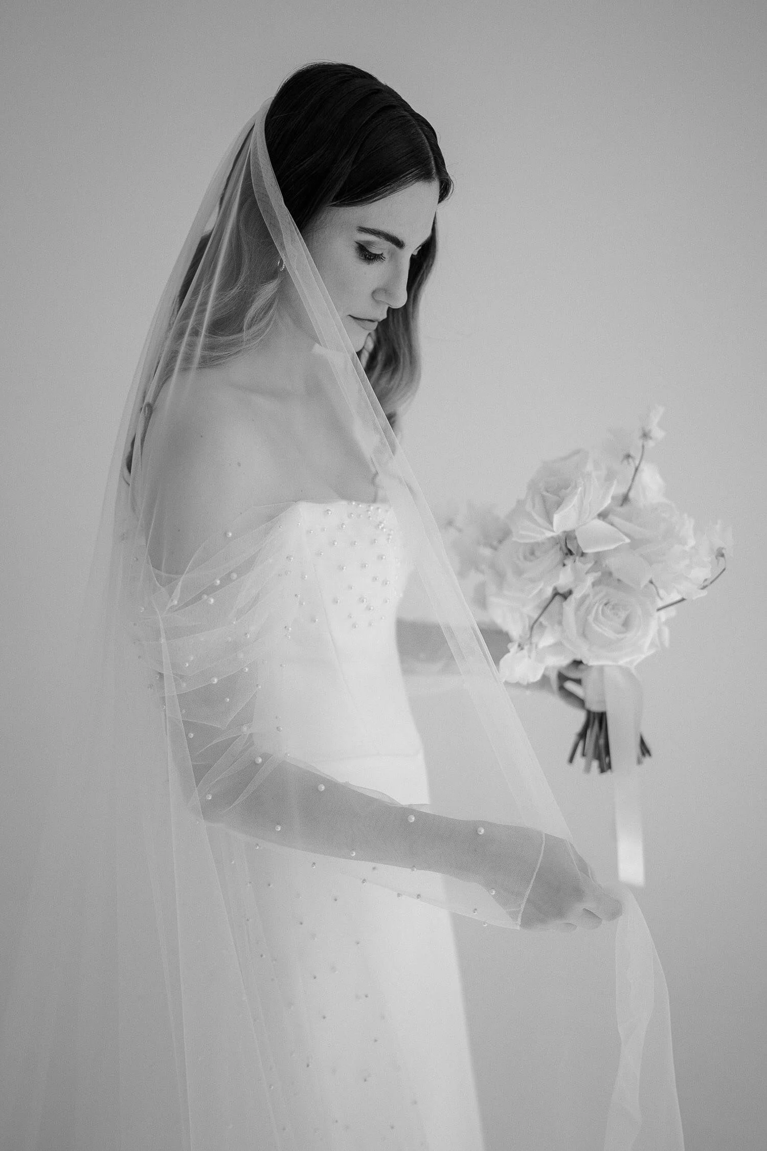 Zeitlose Brautporträt mit Schleier und Rosenstrauß