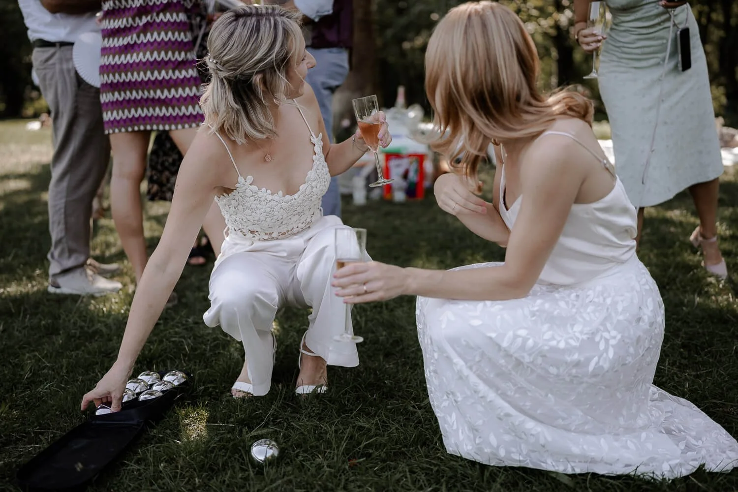 Braut spielt Boule nach Hochzeit im Park bei Mandlstraße München