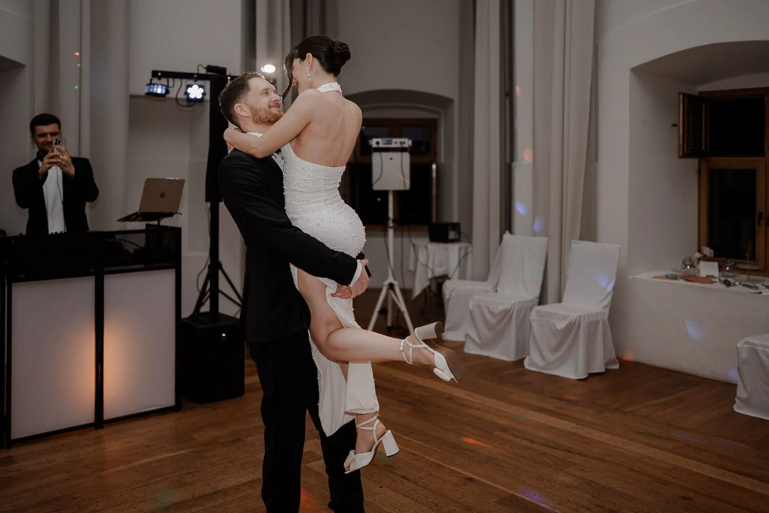 Hochzeitstanz im Schloss Hohenkammer – Bräutigam hebt Braut lachend hoch.