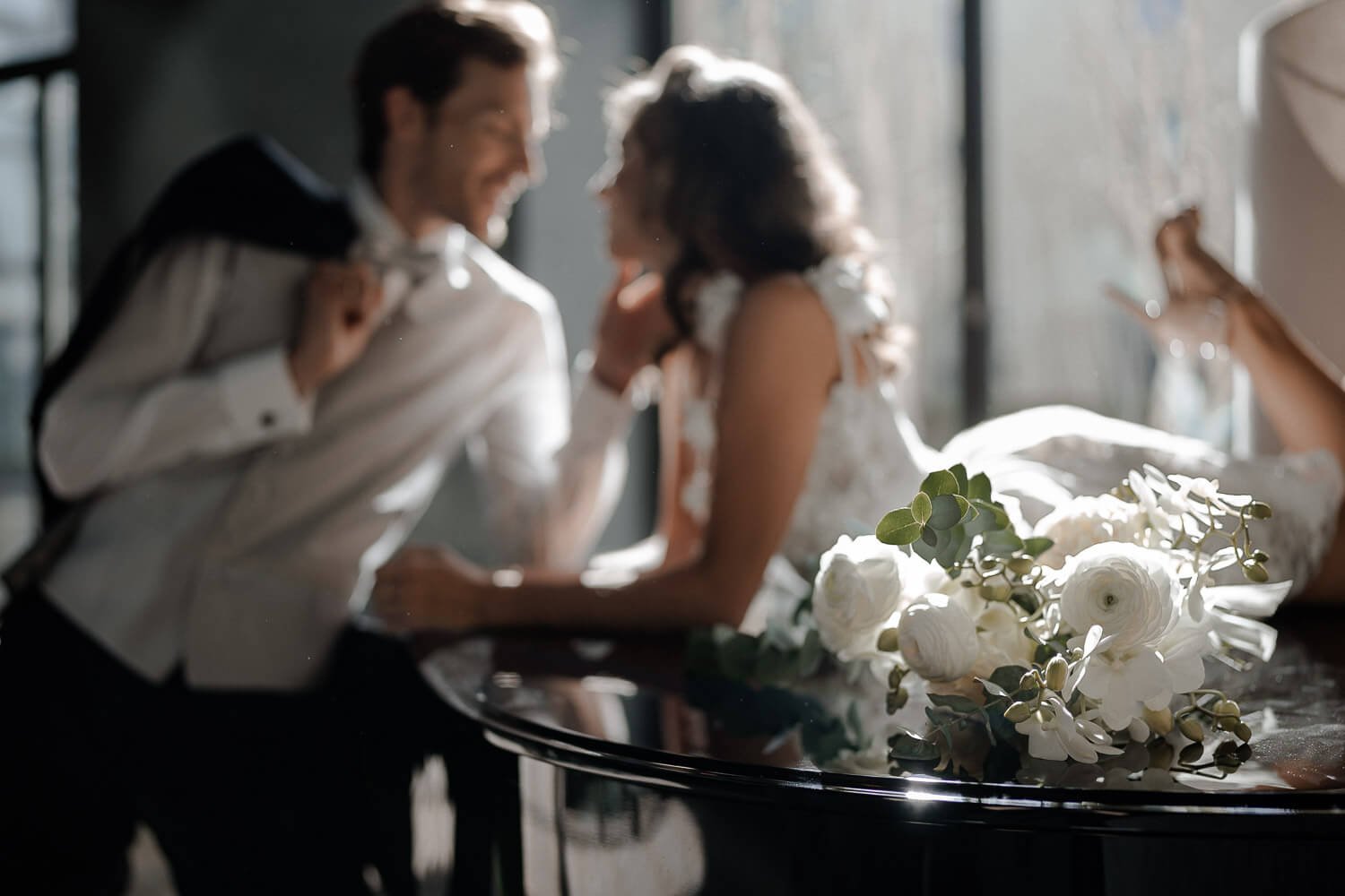 Bouquet im Fokus, Paar im Gegenlicht unscharf – bildstile moderne Hochzeit