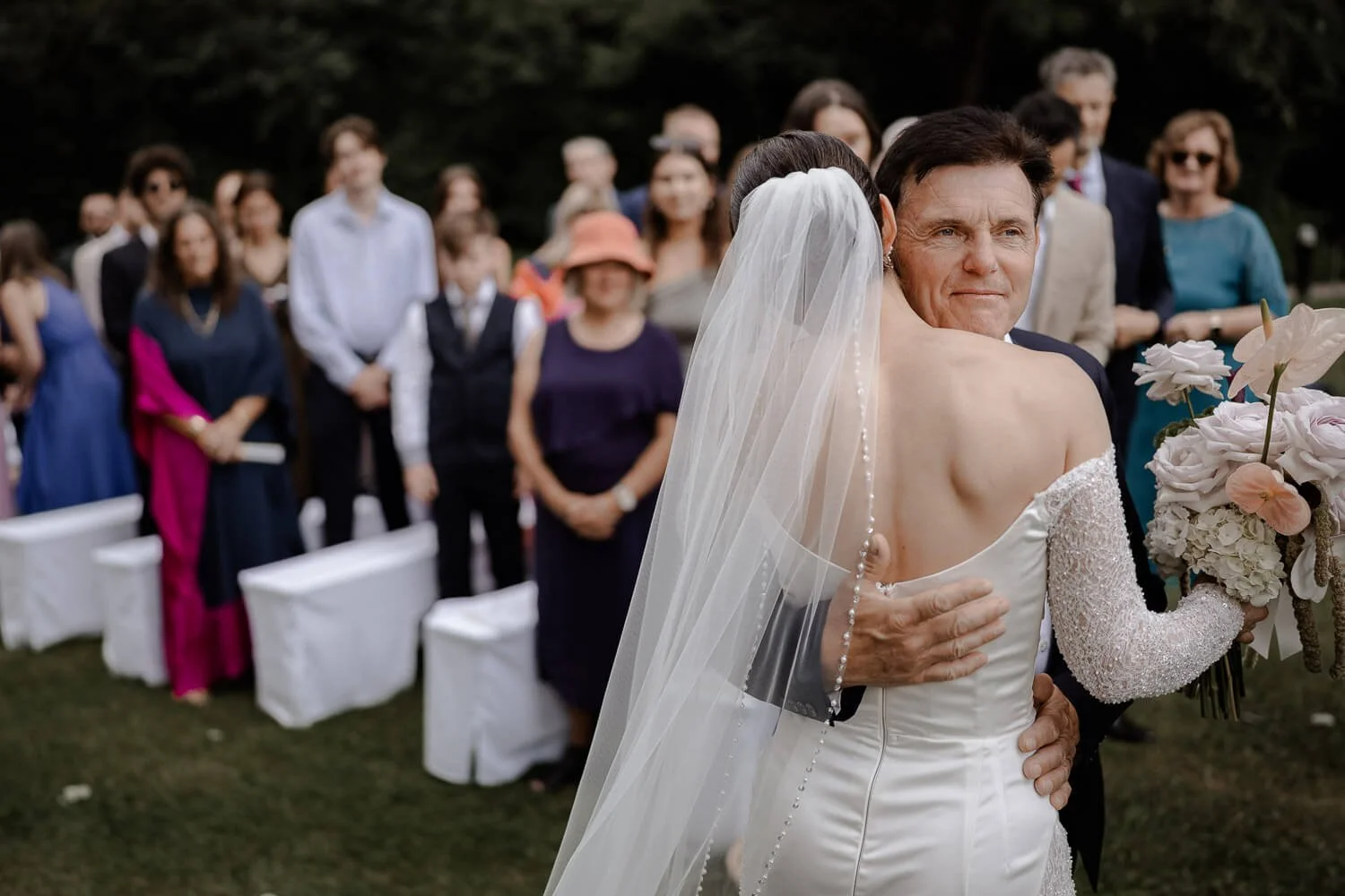 Emotionale Umarmung zwischen Braut und Vater bei Hochzeit.