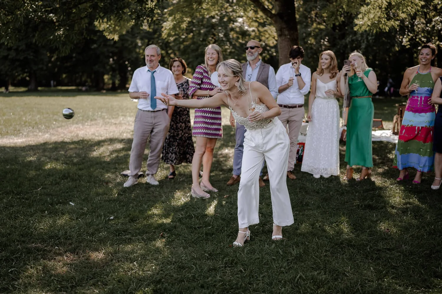 Braut wirft Boulekugel bei Hochzeitsspiel nahe Standesamt Mandlstraße