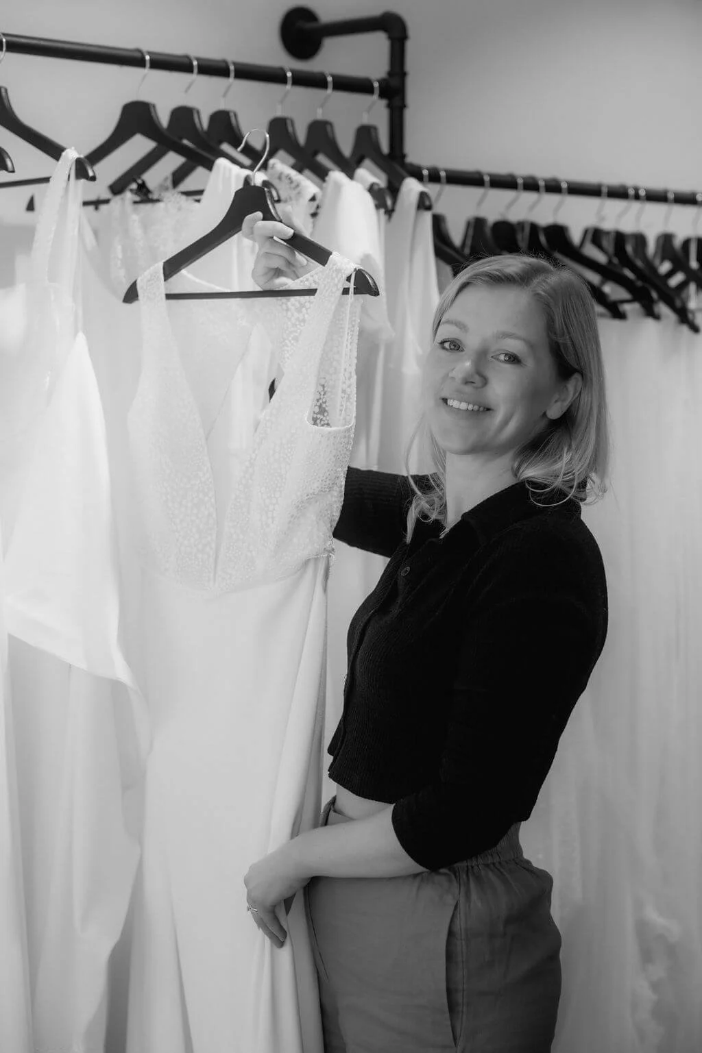 Brautmode München: Stylistin präsentiert Spitzen-Brautkleid am Kleiderständer