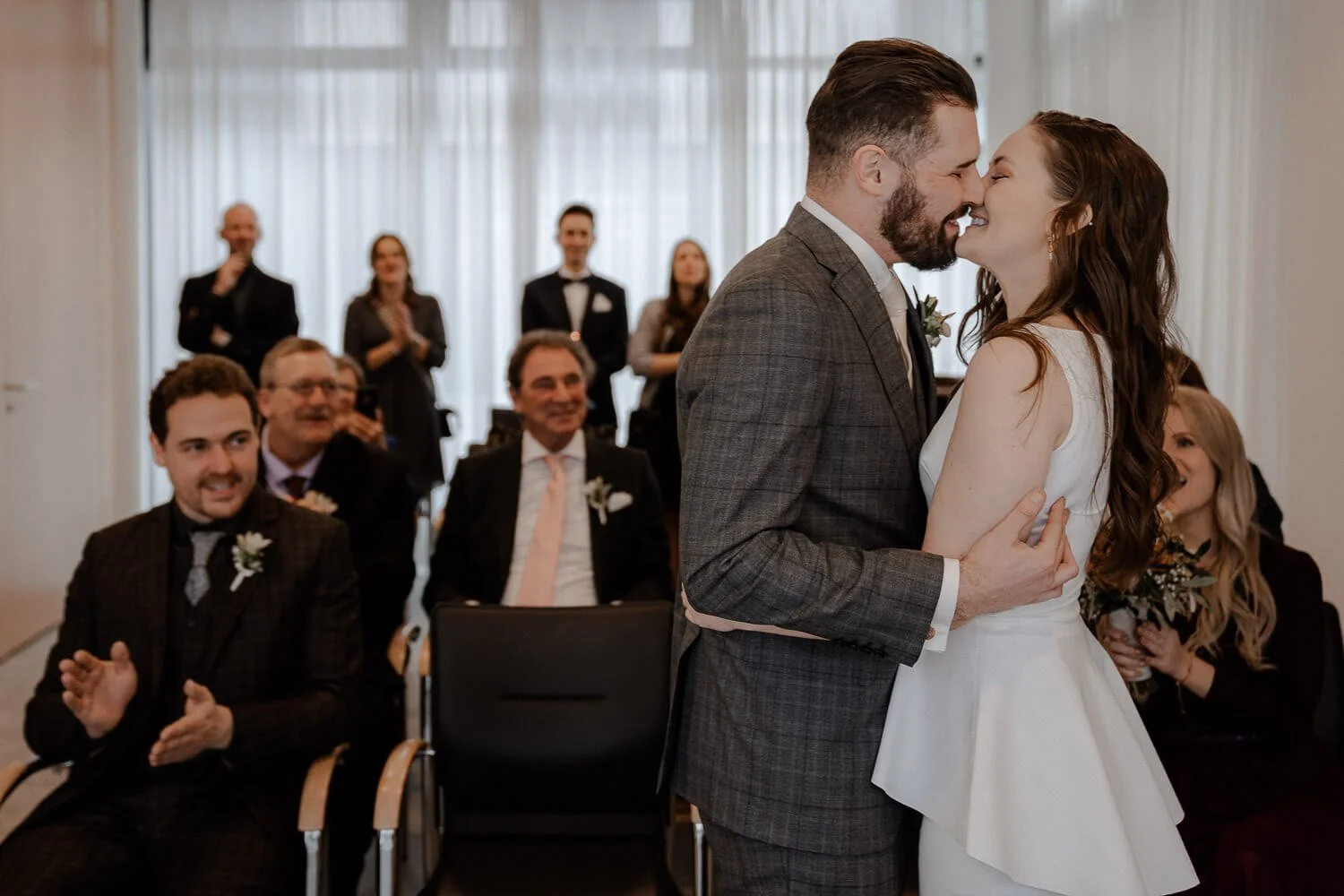 Kuss nach Trauung im Standesamt München Pasing mit applaudierenden Gästen