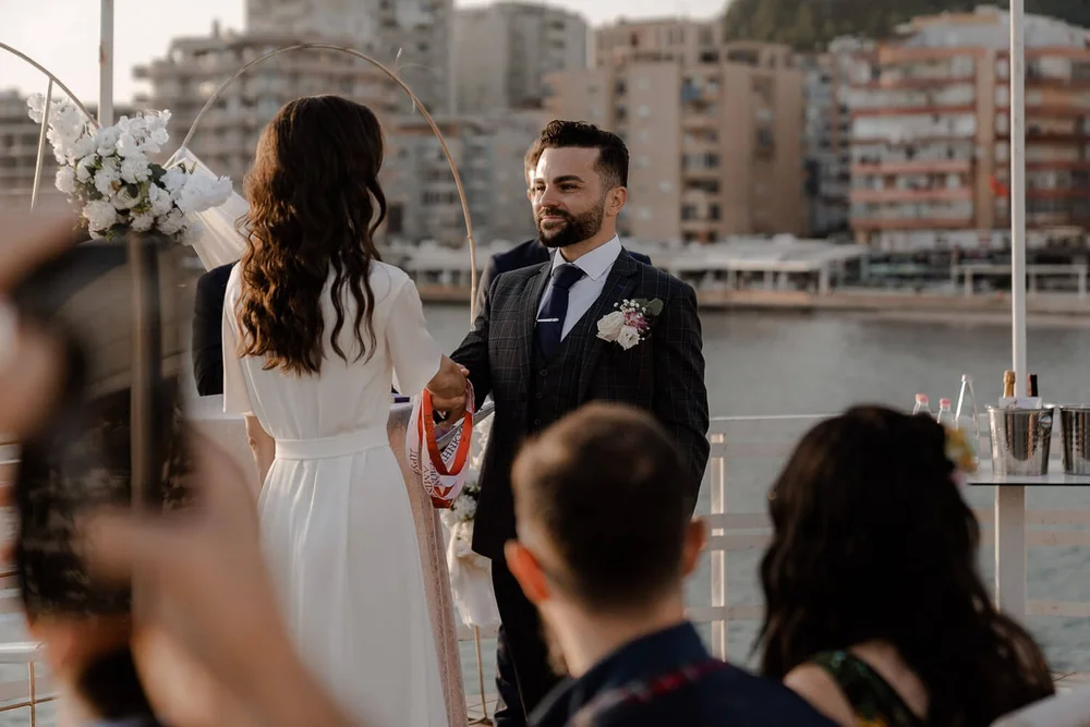 Couple exchanging vows on rooftop with guests