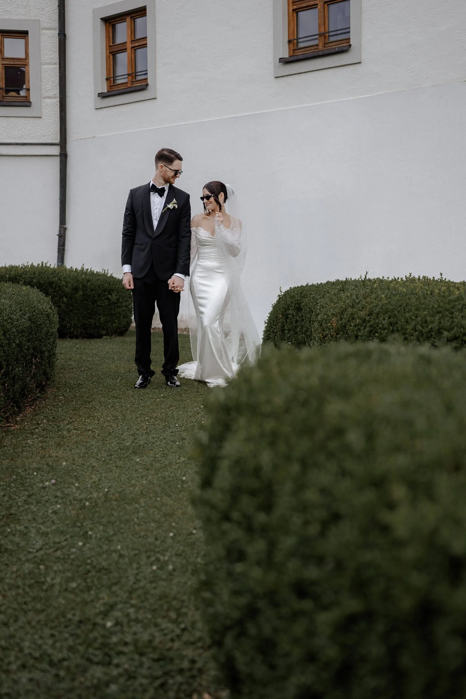 Hochzeitspaar spaziert durch Garten.