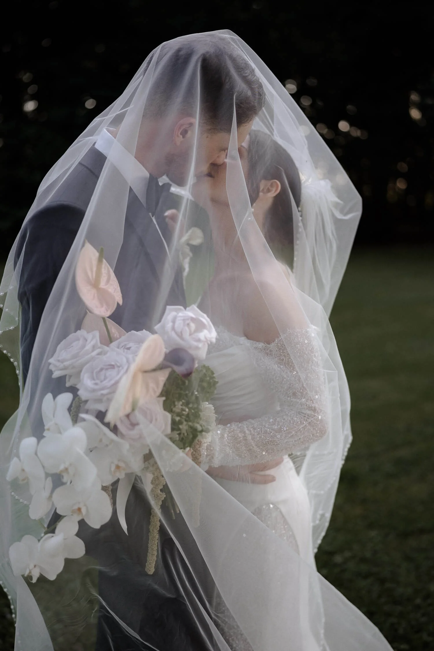 Brautpaar unter Schleier beim Kuss – Hochzeitsfotograf München