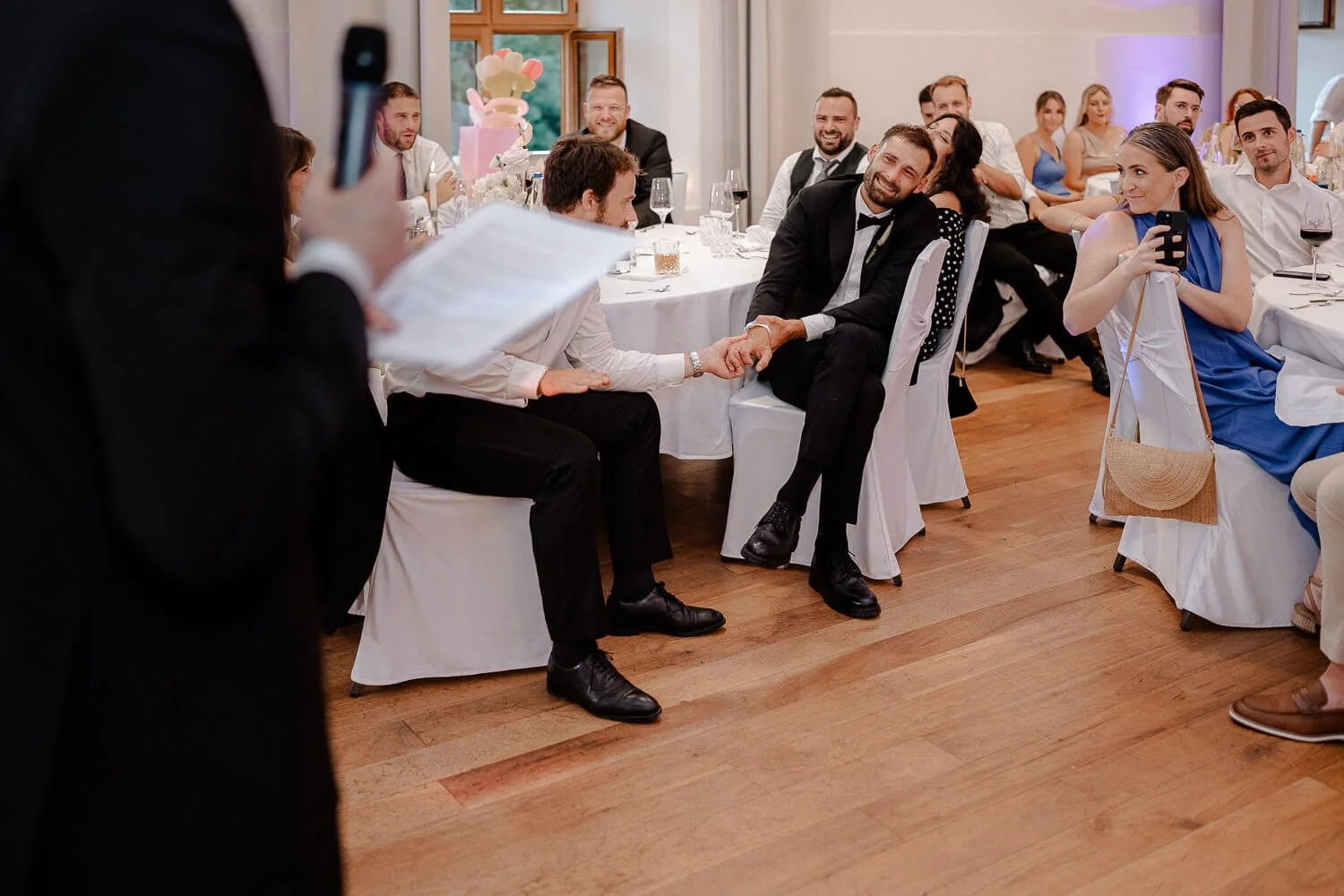 Gäste lachen während emotionaler Rede bei Hochzeit.