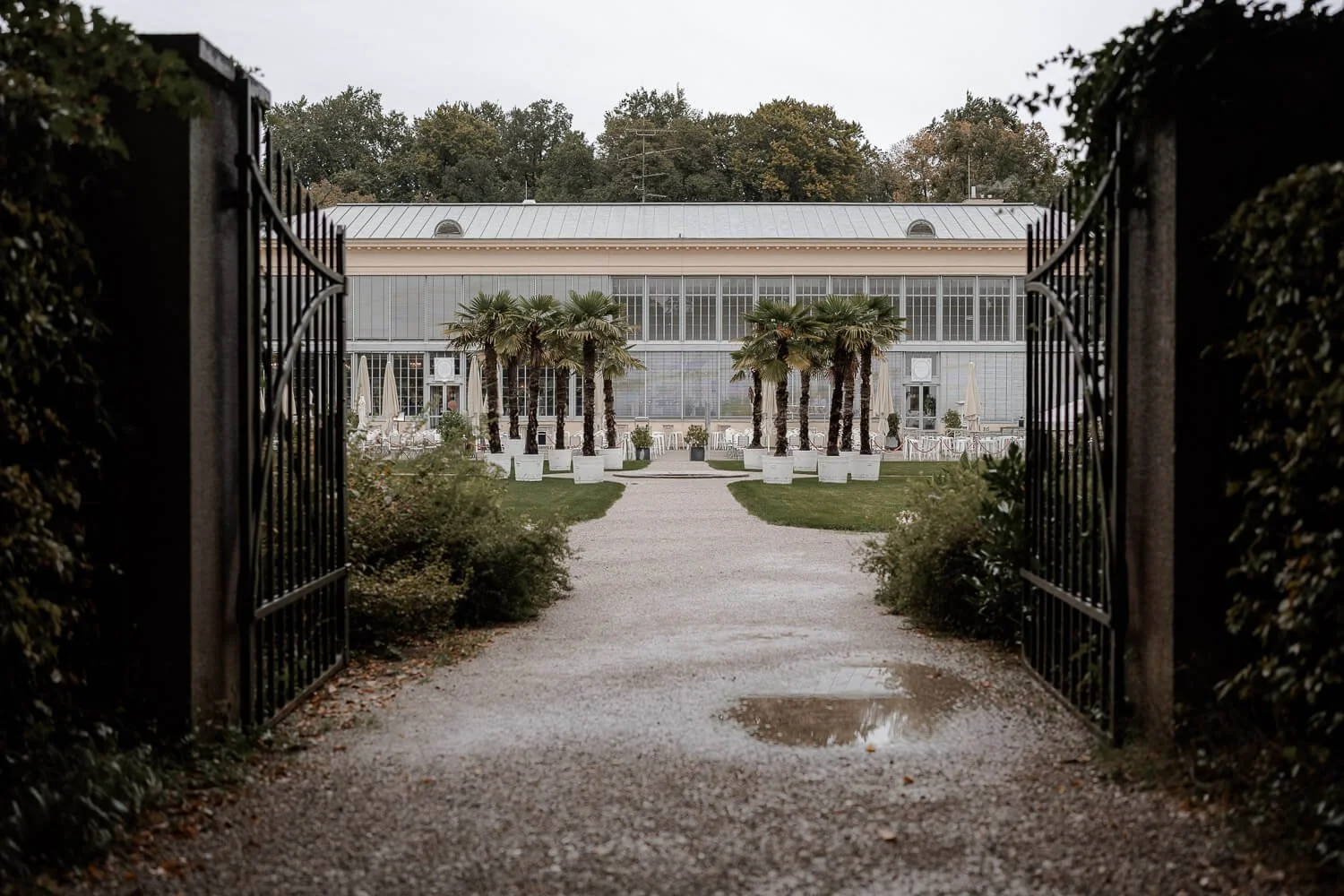 Blick auf das Schlosscafé im Palmenhaus München mit Palmenallee