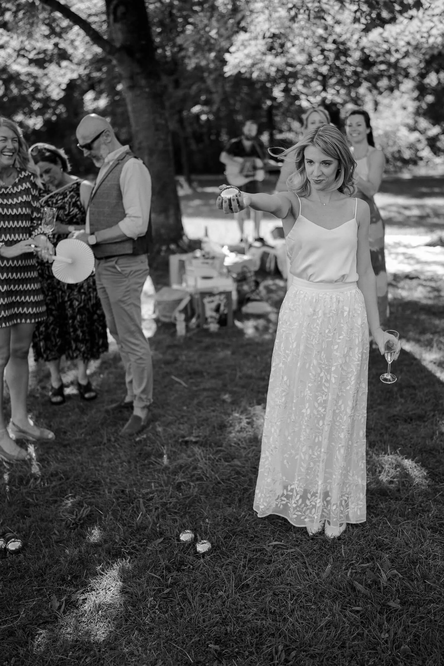Braut spielt Boule nach Hochzeit im Park 