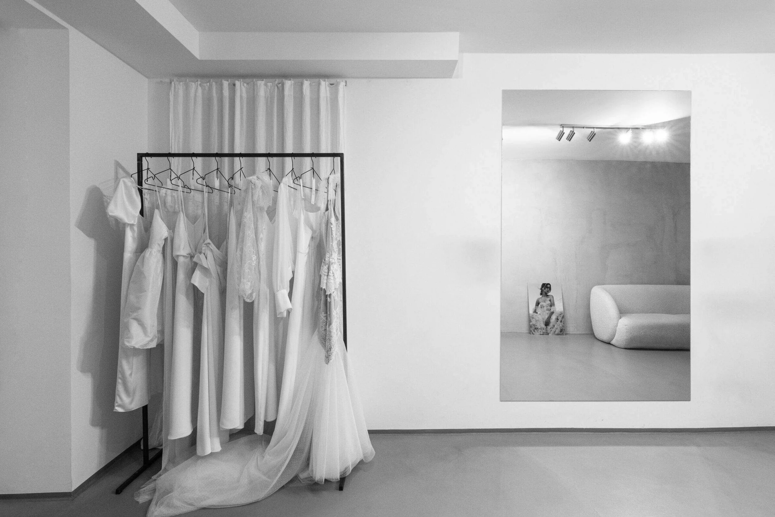 Brautmode München: Kleiderstange mit Brautkleidern im minimalistischen Atelier