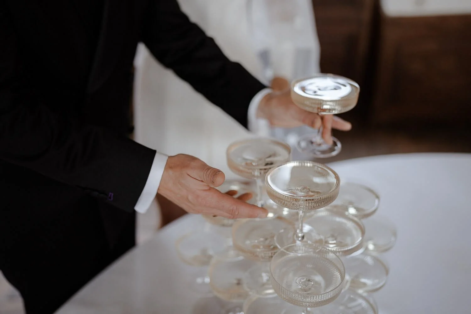 Hand richtet Champagnergläser – Hochzeit Profi Fotograf Detailshot